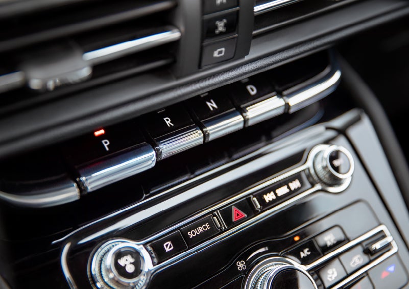 The Park button on the elegant Piano Key Shifter is lit up and engaged as light dances off the chrome accents and horizontal design lines | Pugmire Lincoln of Marietta in Marietta GA