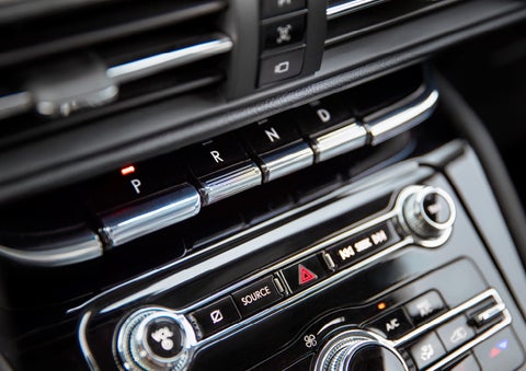 The Park button on the elegant Piano Key Shifter is lit up and engaged as light dances off the chrome accents and horizontal design lines | Pugmire Lincoln of Marietta in Marietta GA