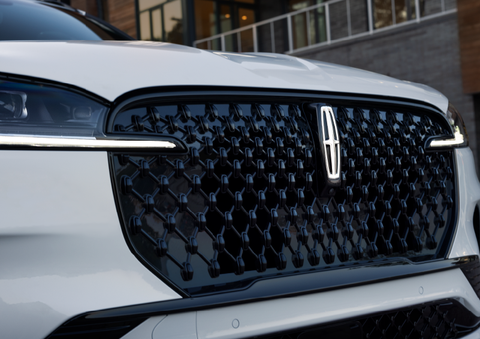 The black grille of a white 2025 Lincoln Aviator® SUV is shown with its fog lights on. | Pugmire Lincoln of Marietta in Marietta GA