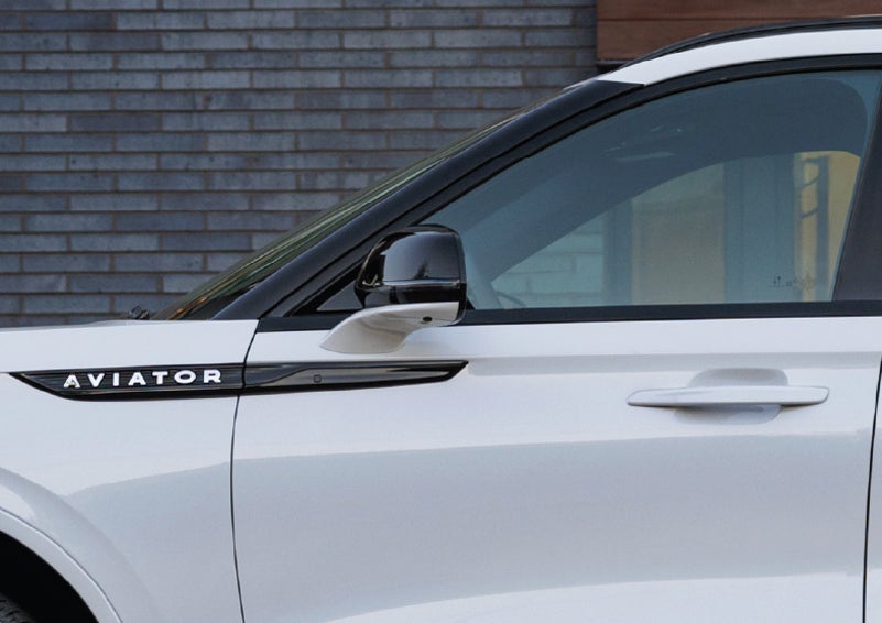 The driver’s side door and fender badging of a white 2026 Lincoln Aviator® SUV are showcased. | Pugmire Lincoln of Marietta in Marietta GA