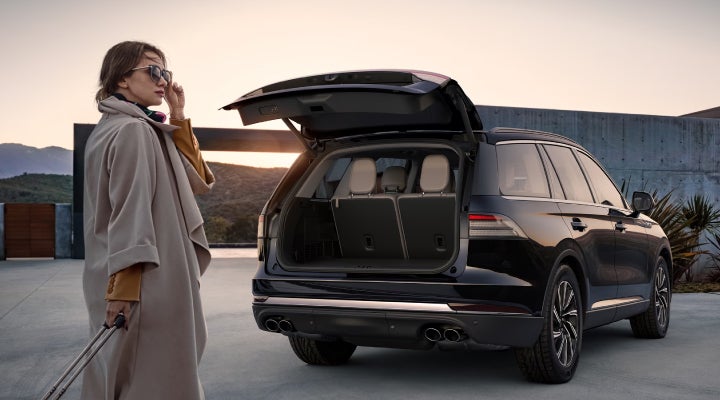 A woman approaches a 2026 Lincoln Aviator® SUV with its rear liftgate open. | Pugmire Lincoln of Marietta in Marietta GA