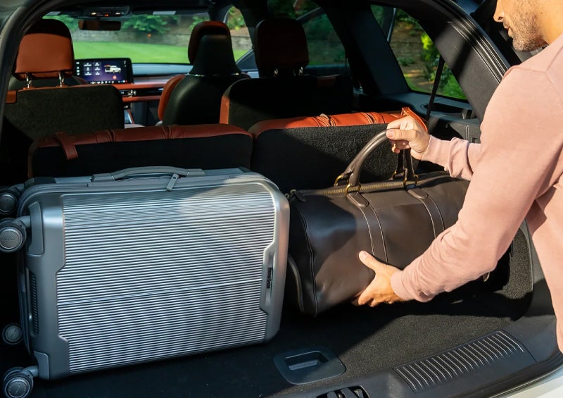 A man loads luggage into the rear of a 2026 Lincoln Aviator® SUV through the opened rear liftgate. | Pugmire Lincoln of Marietta in Marietta GA