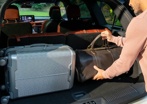 A man loads luggage into the rear of a 2026 Lincoln Aviator® SUV through the opened rear liftgate. | Pugmire Lincoln of Marietta in Marietta GA