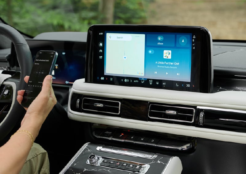A person pairs thier phone with the center touchscreen of a 2027 Lincoln Aviator® Black Label™ SUV | Pugmire Lincoln of Marietta in Marietta GA