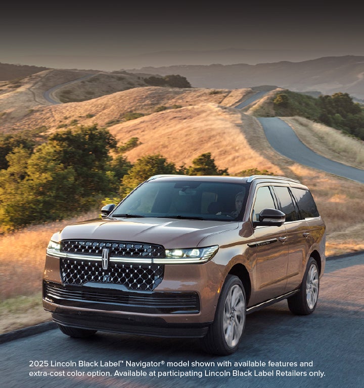 A 2025 Lincoln Navigator® SUV is being driven on a country road.